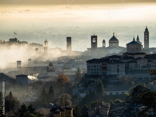 Bergamo, Italy. Amazing aerial landscape of the fog rises from the plains and covers the old town during sunrise. Bergamo one of the most beautiful city in Italy