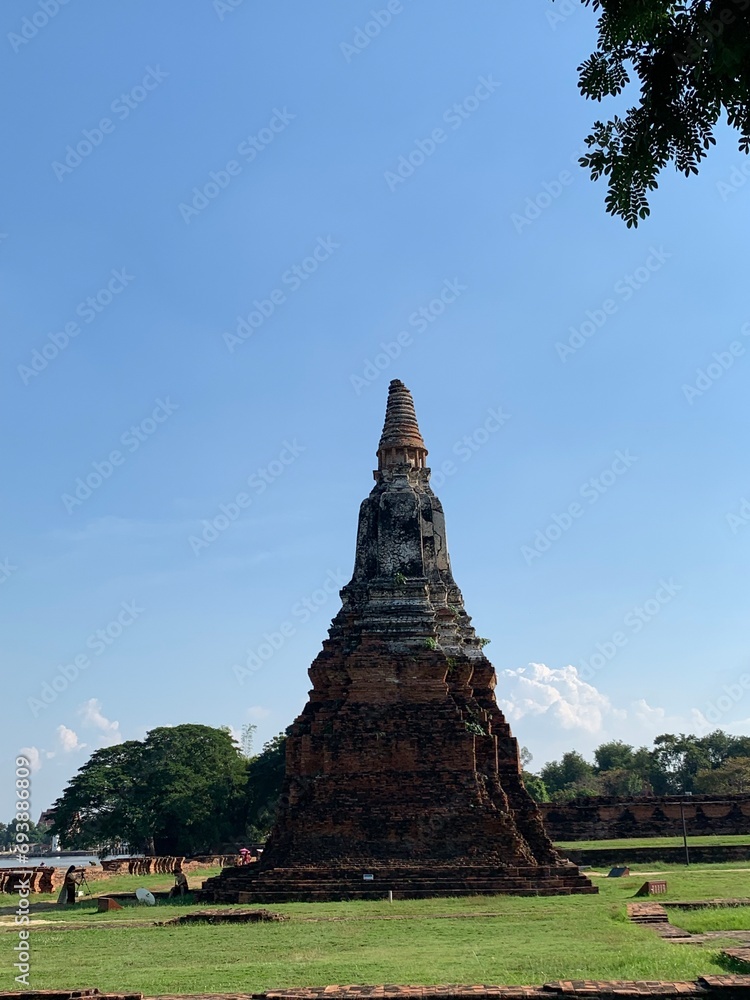 Ancient stupas, pagodas, lots of orange bricks lined up. Temples within the ancient city of Ayutthaya in blue sky day