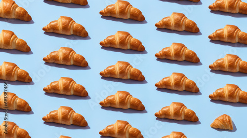 Croissant pattern on a blue background. Appetizing buns. Bakery art.