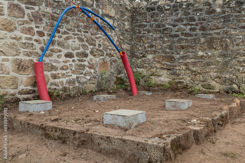 Etape d'insertion de tuyaux dans un conduit rouge pour le montage d'une installation solaire thermique destinée à fournir de l'eau chaude. photo