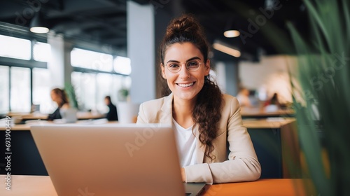 Young and beautiful woman working with laptop in office