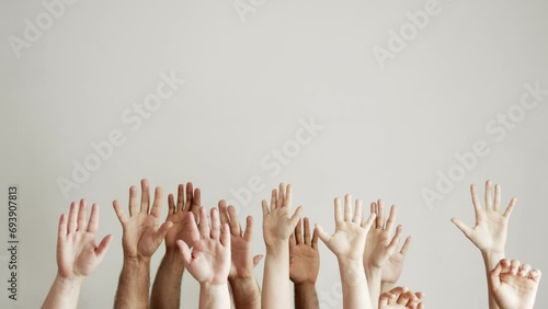 Many hands of different colors and sizes on a white background are raised up forward with palms. Forest of hands. Volunteers photo