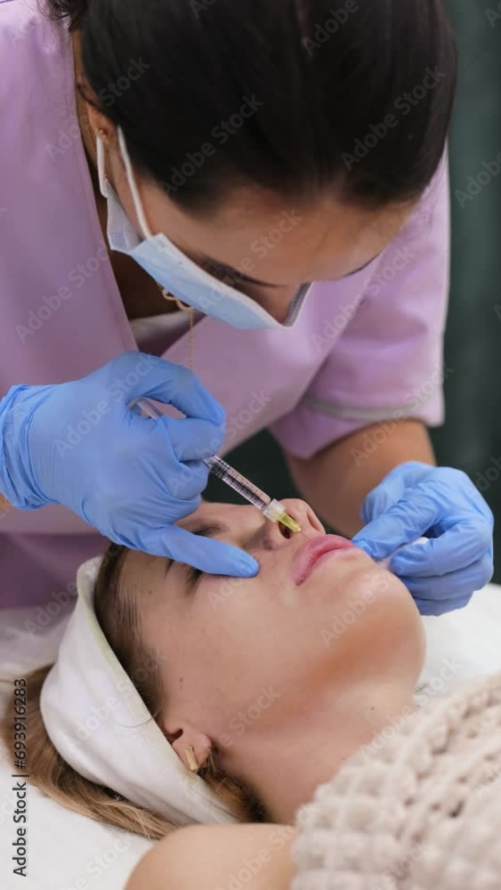cosmetologist makes injections to enlarge the lips of beautiful woman. procedure lip augmentation cosmetologist makes injections to enlarge the lips of beautiful woman. procedure lip augmentation
