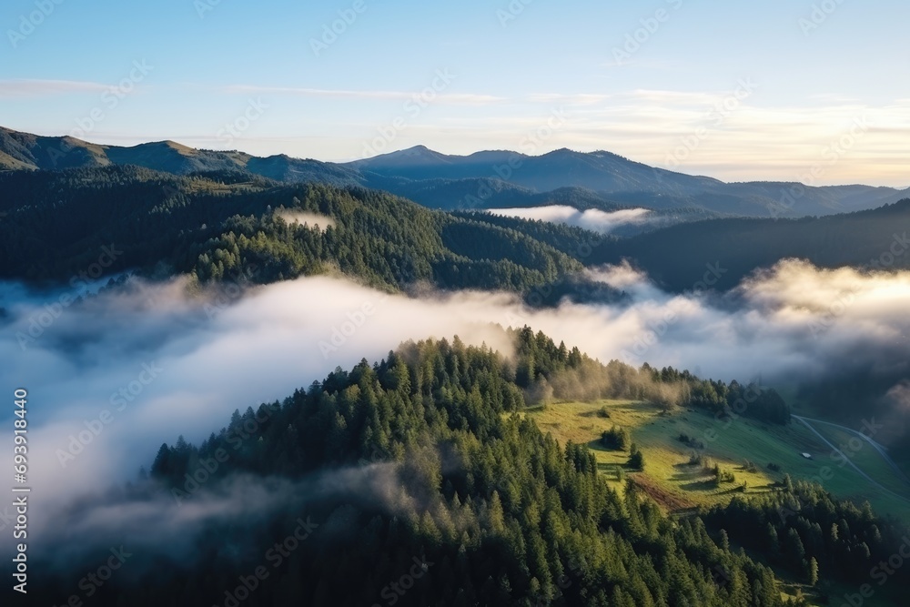 Amazing aerial view of beautiful low clouds mountains. Top view over green hills, trees, road, and steep cliffs. Amazing aerial view of beautiful low clouds mountains. Top view over green hills, trees, road, and steep cliffs.
