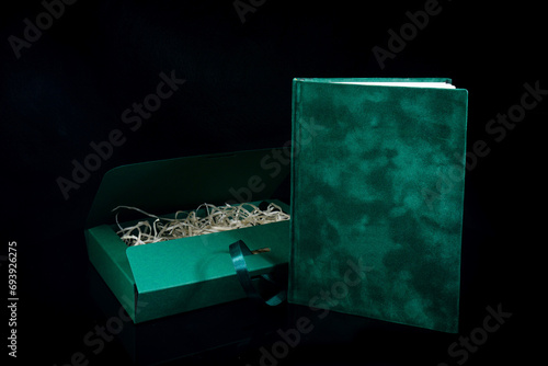 Best gift for men. Man gift concept. Green notebook with Green gift box on black background. Copy space text. Valentine's day, wedding, birthday and special occasion gift concept. Copy space for text.