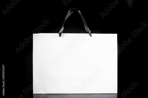 Recyclable white paper bag for purchases, gifts and takeaway food mock up on black background. Environmentally friendly than single-use plastic bags