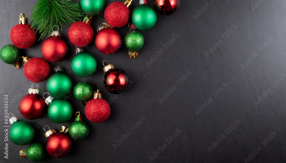 Green and red Christmas baubles decoration on dark black background with copy space. Green and red Christmas baubles decoration on dark black background with copy space.