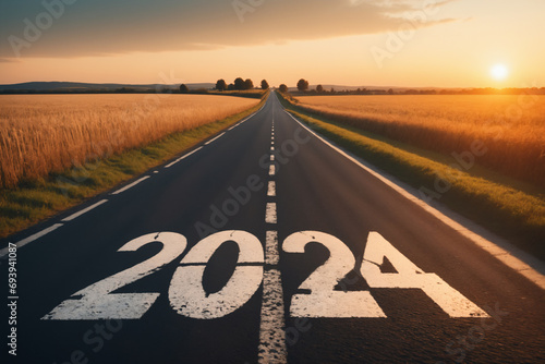 View of a landscape with a road running through it in the center reaching to the horizon. The writing 2024 on the asphalt - New Year and business concept photo