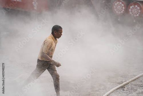 Bore Well Drilling in Progress with a Dedicated Helper Collaboration and Dust in indian street stock images, hard worker, indian labors 