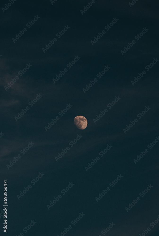 Moon in its full glory, illuminated by the last remnants of orange-red light from the sun, in a dark sky. Beskydy mountains, Czech Republic Moon in its full glory, illuminated by the last remnants of orange-red light from the sun, in a dark sky. Beskydy mountains, Czech Republic