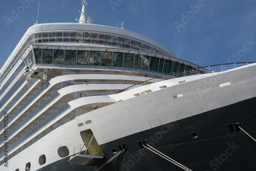 Classic british luxury ocean liner cruiseship cruise ship in port with detail view of steel hull, bow, superstructure and bridge in black, white and red color paint © Tamme