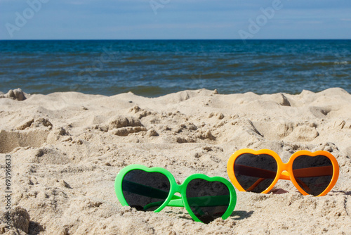Colorful sunglasses at beach. Sun protection while sunbathing. Travel and vacation time