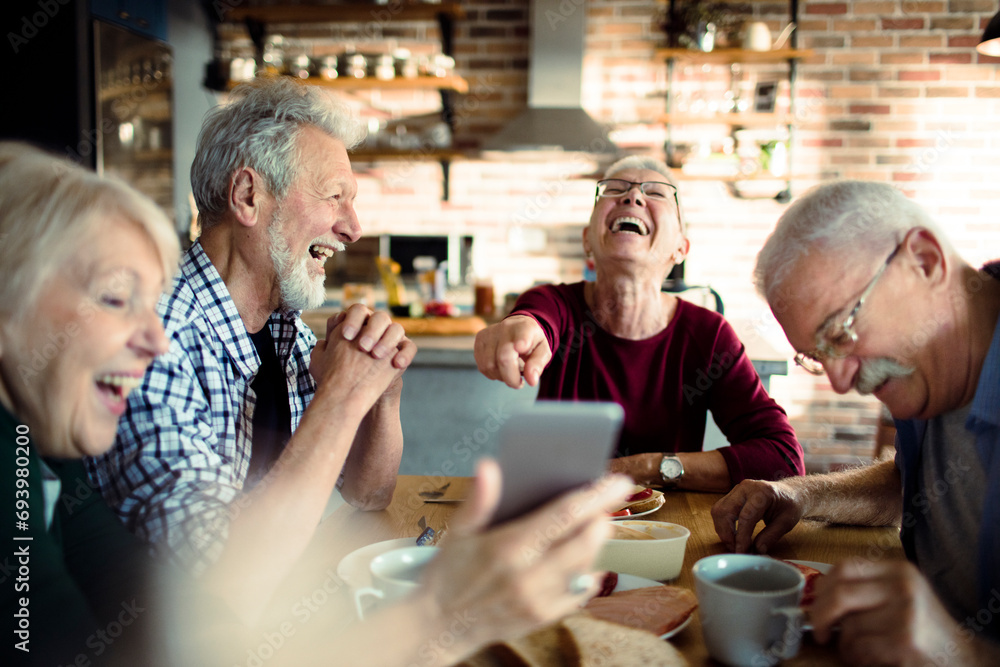 Happy senior people eating together at home