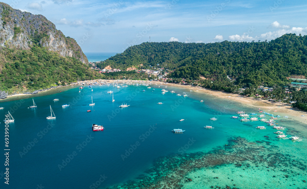 Naklejka premium Drone view of a traditional philippine boats on the surface of the azure water in the lagoon. Summer and travel vacation concept