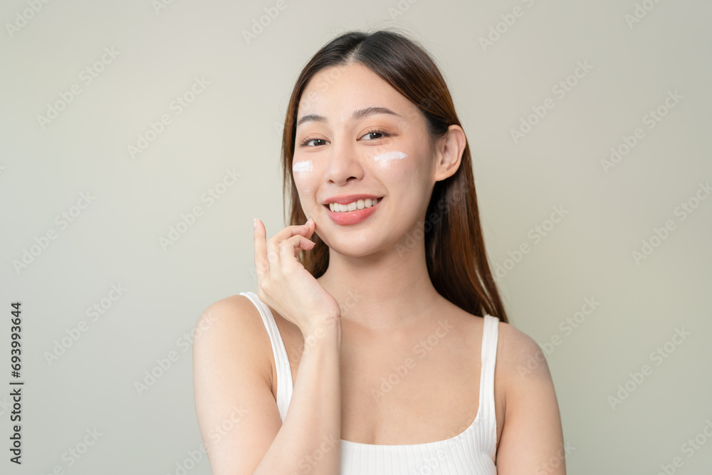 wellness care concept, young woman looking at the mirror and applying facial skin care cream on her face wellness care concept, young woman looking at the mirror and applying facial skin care cream on her face