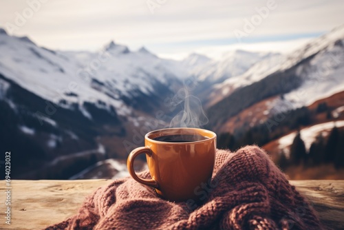 Woman's feet in wooly socks enjoying the view of the Alps, sipping a warm beverage, in a festive winter setting. photo