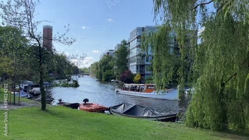 Boat driving along canal in Amsterdam, Netherlands