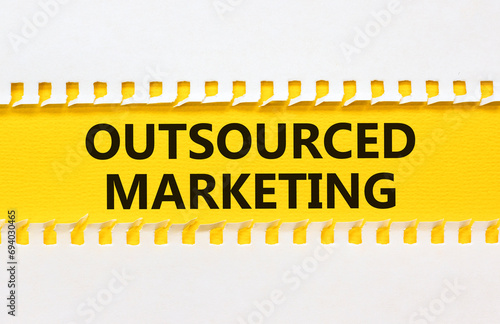 Outsourced marketing symbol. Concept words Outsourced marketing on beautiful yellow paper. Beautiful white paper background. Business Outsourced marketing concept. Copy space.