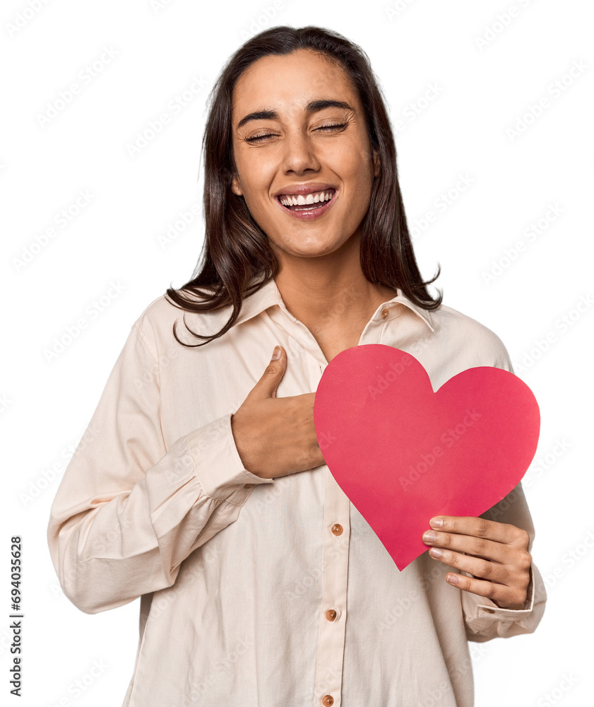 Caucasian young woman with paper heart for Valentine's laughs out loudly keeping hand on chest. Caucasian young woman with paper heart for Valentine's laughs out loudly keeping hand on chest.