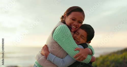 Children, hug and love outdoor at the beach for adventure, travel or holiday with care and happiness. A young boy and girl, happy siblings or kids together for fun family vacation in nature at sunset photo