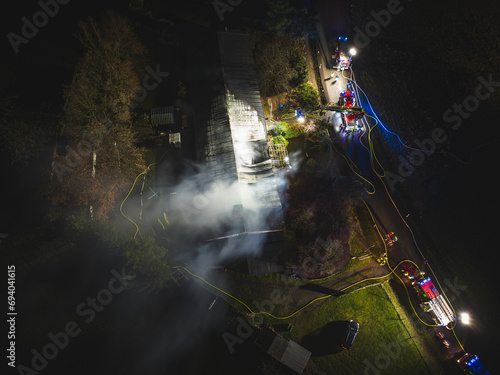 Drohnenaufnahme einers brennenden Gebäudes mit zahlreichen Fahrzeugen der Feuerwehr vor Ort.....15.12.2023 photo