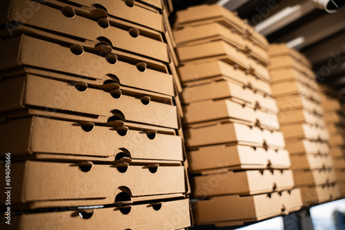 Close-up of a stack of brown pizza delivery boxes.