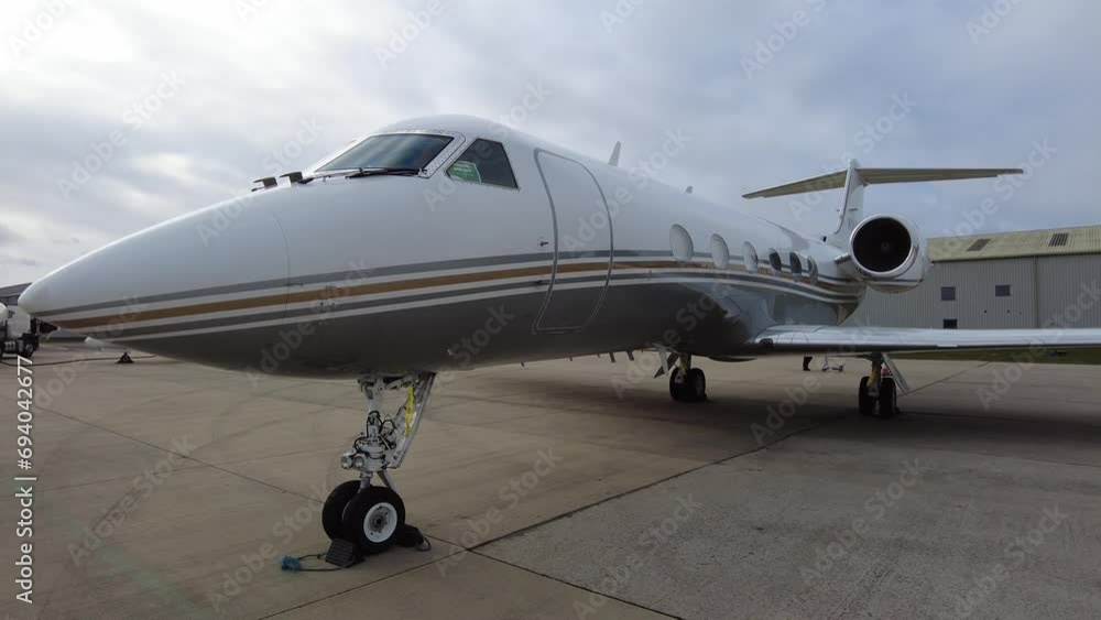 Private Jet parked at airport close up panning shot tail to cockpit along fuselage