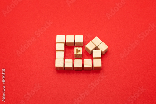 赤い背景のリプレイマークの形をしたウッドキューブ