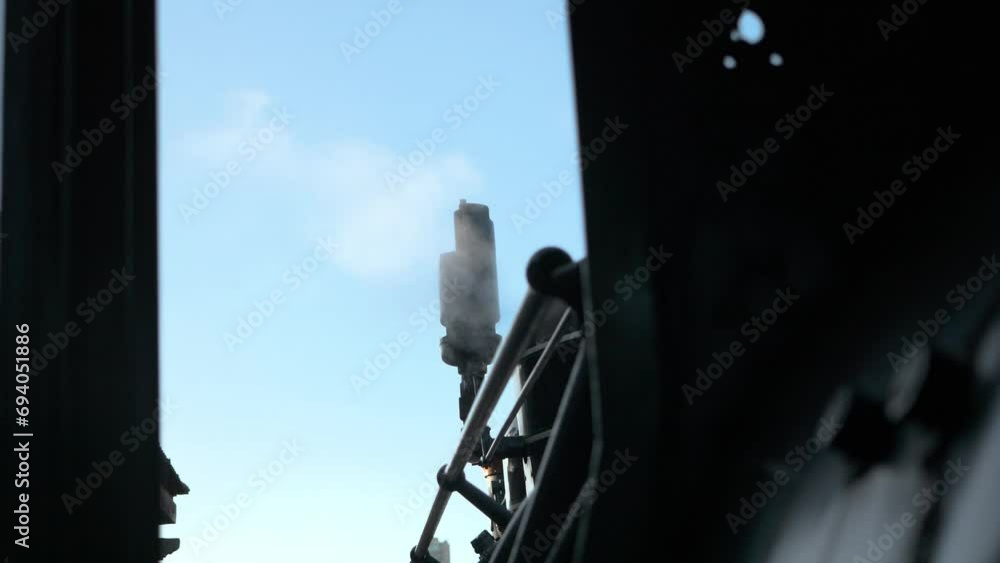 19th century USA train powered by steam through a boiler fed by wood firewood by an operator, chimney emitting a lot of smoke upon departure 19th century USA train powered by steam through a boiler fed by wood firewood by an operator, chimney emitting a lot of smoke upon departure