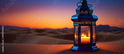 Arabic lantern with candle in desert during blue hour. Greeting card for Ramadan in Dubai, UAE.