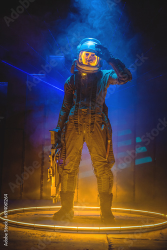 Spaceman or star trooper in the helmet and with rifle in dark teleporting through the portal concept. Science fiction concept. Outer space travel.