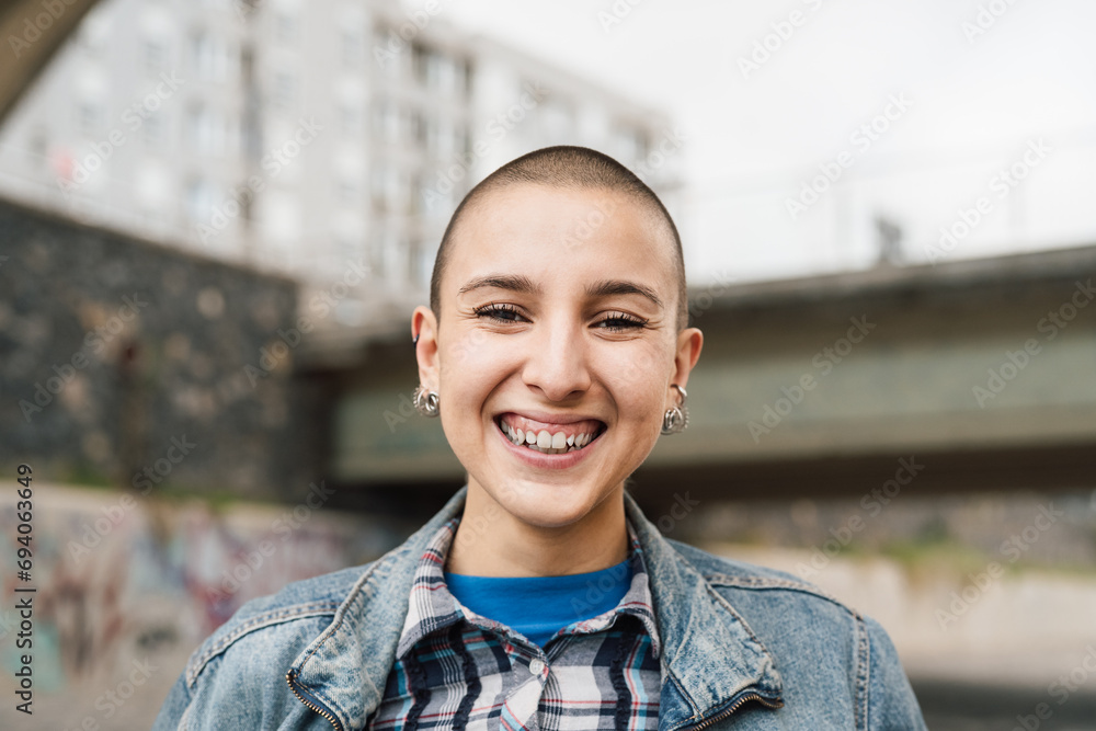 Naklejka premium Happy young woman with shaved head smiling in front of camera