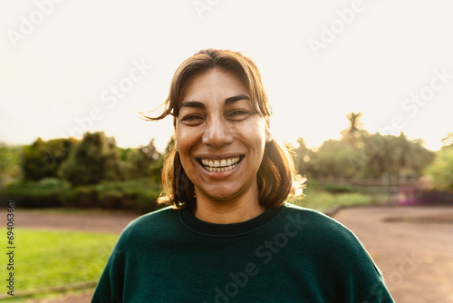 Happy Latin woman having fun smiling in the camera in a public park photo