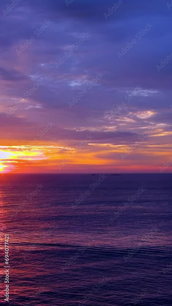 In morning, sun rises over ocean as waves of ocean are being broken by waves