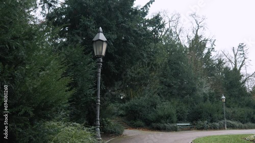 An old lantern in the park near big Christmas trees. Camera movement. photo