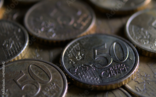 50 euro cent coin lying in a row of coins. Macro photography in dark tones.