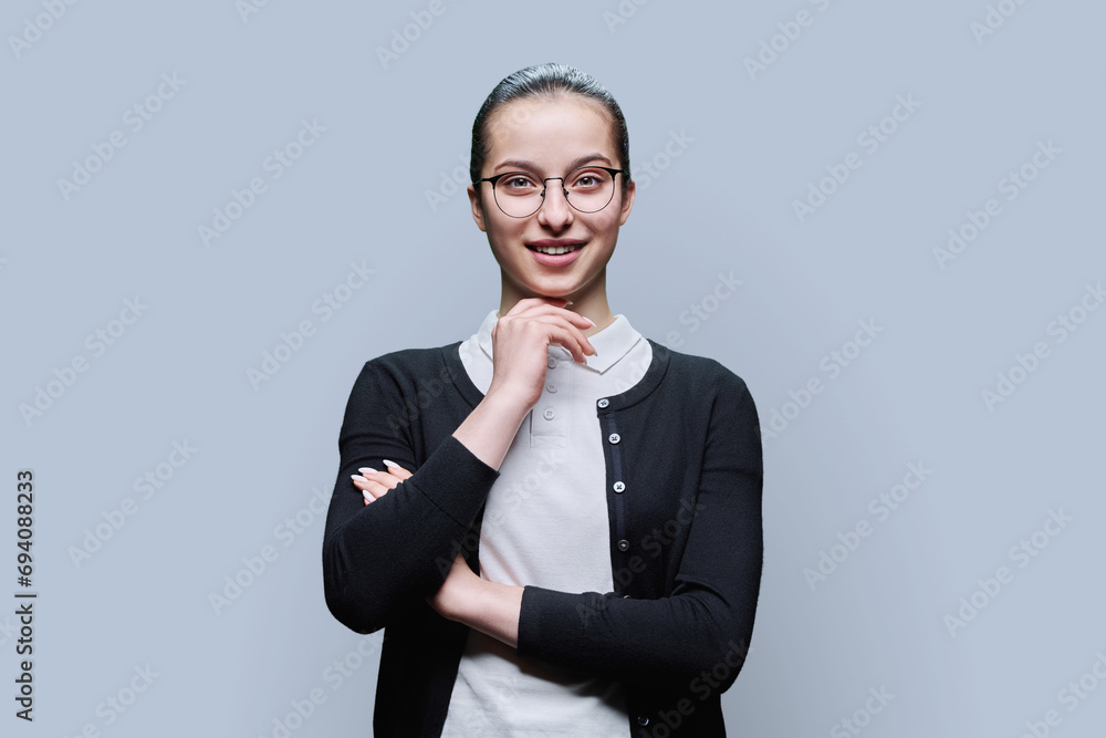Portrait of smiling teenager girl on grey background Portrait of smiling teenager girl on grey background