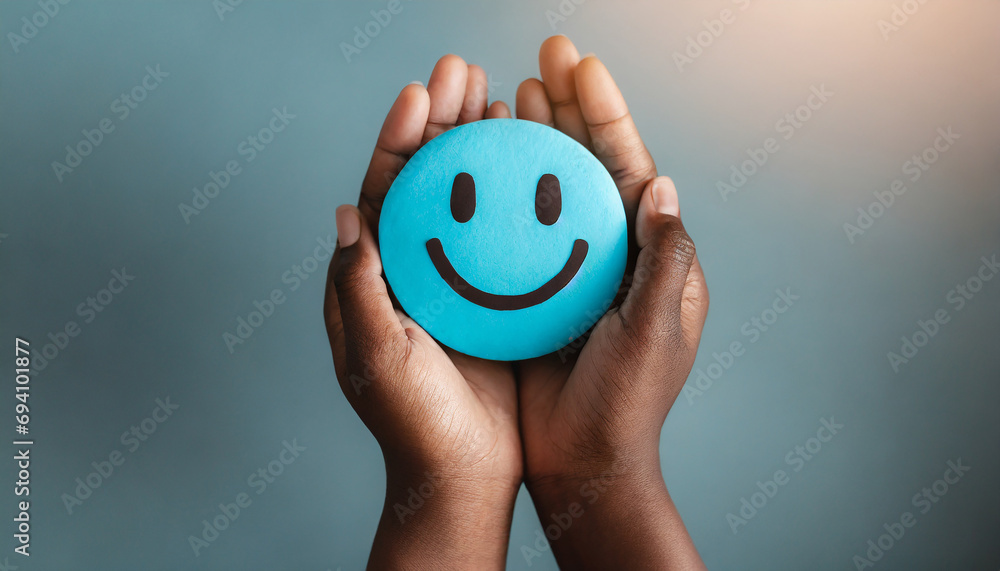 Hands holding blue happy smile face. mental health positive thinking and growth mindset, mental health care recovery to happiness emotion. - obrazy, fototapety, plakaty 