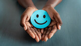 Hands holding blue happy smile face for medical care concept. mental health positive thinking.