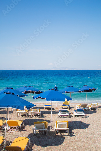 Vacation concept: empty beach with sunbeds and umbrellas, Blue sea in the background. Free copy space