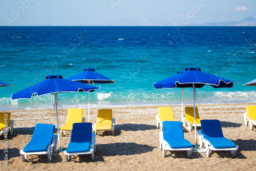 Summer and holiday concept: beach chairs and umbrellas, no people, empty beach, beautiful blue sea