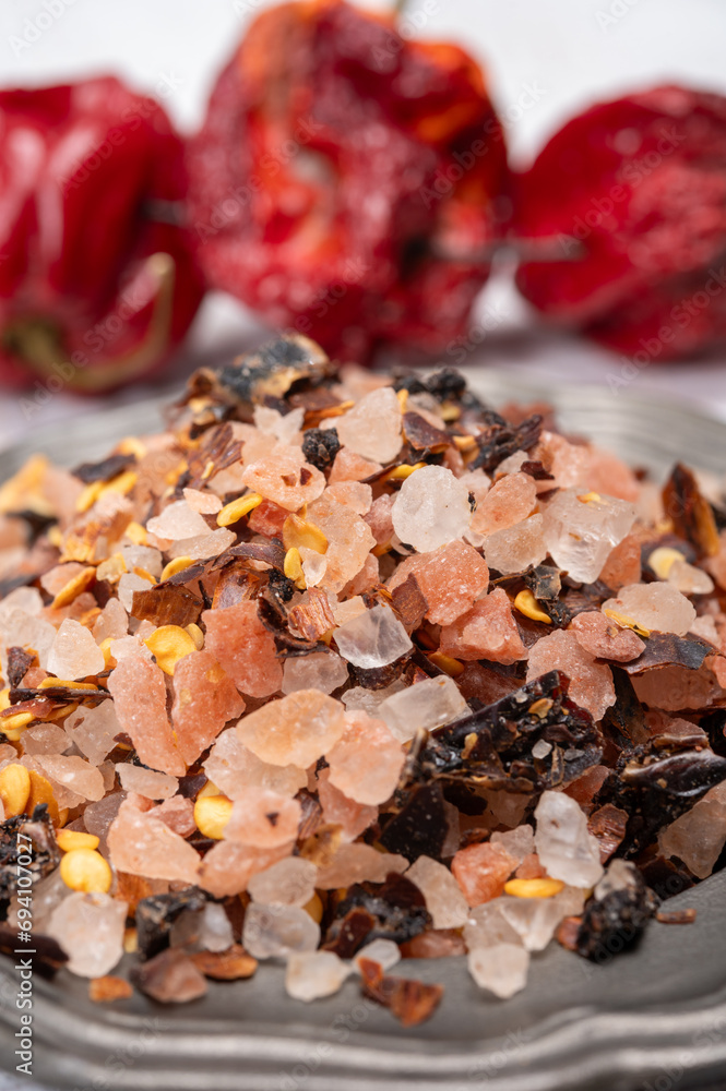 Pink himalayan salt chrystals with dried seeds of red hot chili peppers and herbs, cooking with exotic salt Pink himalayan salt chrystals with dried seeds of red hot chili peppers and herbs, cooking with exotic salt