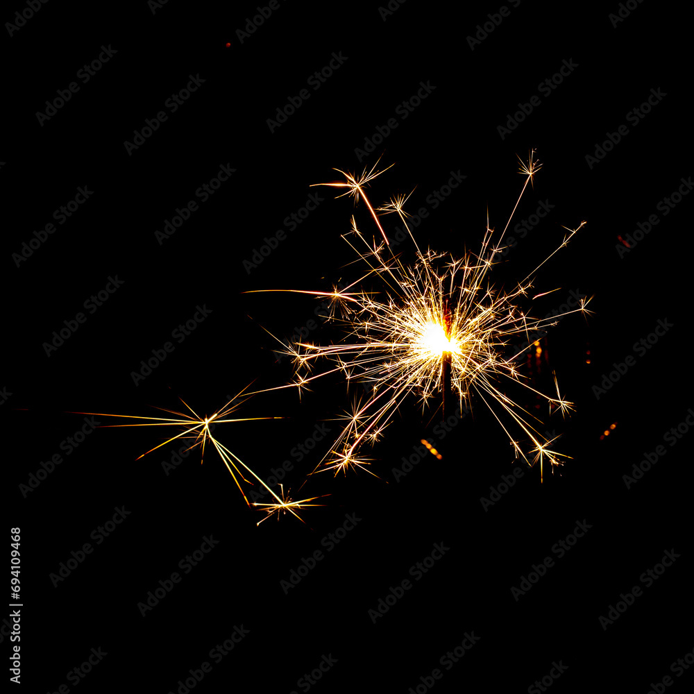 burning sparkler with flying sparks on a dark background