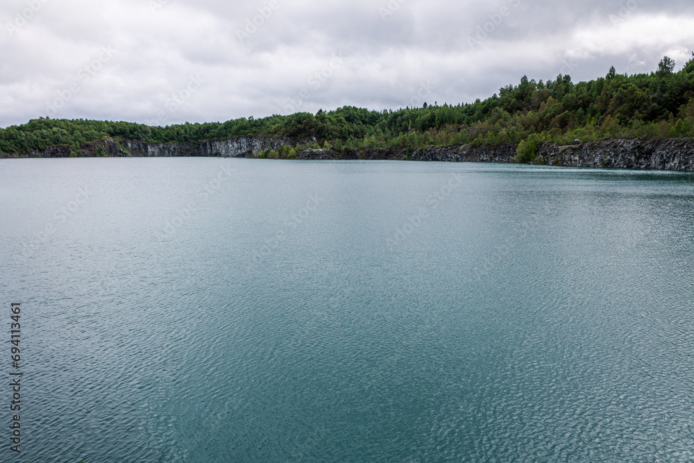 Cold mountain lake with clean transparent water, Northern quarry pond wide