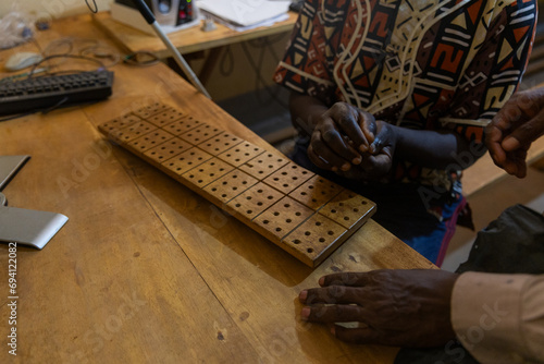 African lecturer and his student during a lesson on wooden braille alphabet tablet
