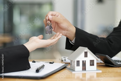 real estate agent giving house keys to client after signing contract