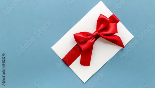 blank gift card with red bow on light blue background top view space for text