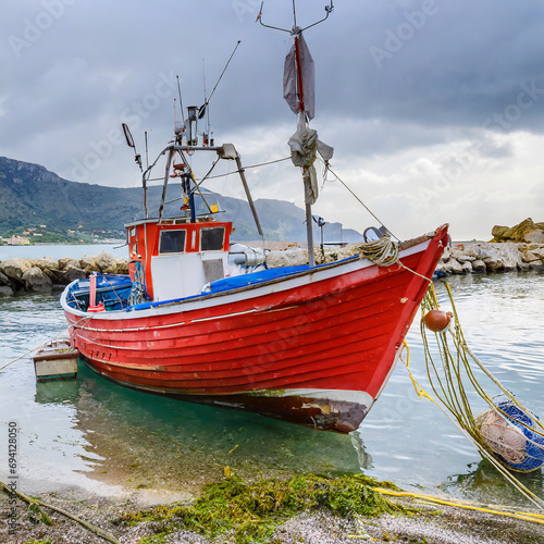 Red fishing boat moored and waiting for the next catch