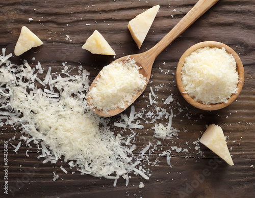 Grated parmesan cheese in spoon isolated on white background, top view © Adam