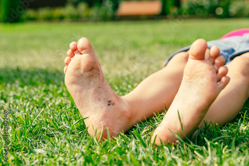 Child's bare feet on green grass in park. Kid foot on green grass on garden. Barefoot concept, freedom, relax and healthy feet. © Irina Mikhailichenko